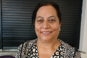 Headshot of a middle aged woman smiling at the camera. Shoulders upwards.
